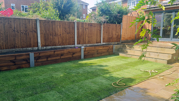 fresh mown lawn and wooden fencing in modern home garden by Bizzy in the Garden